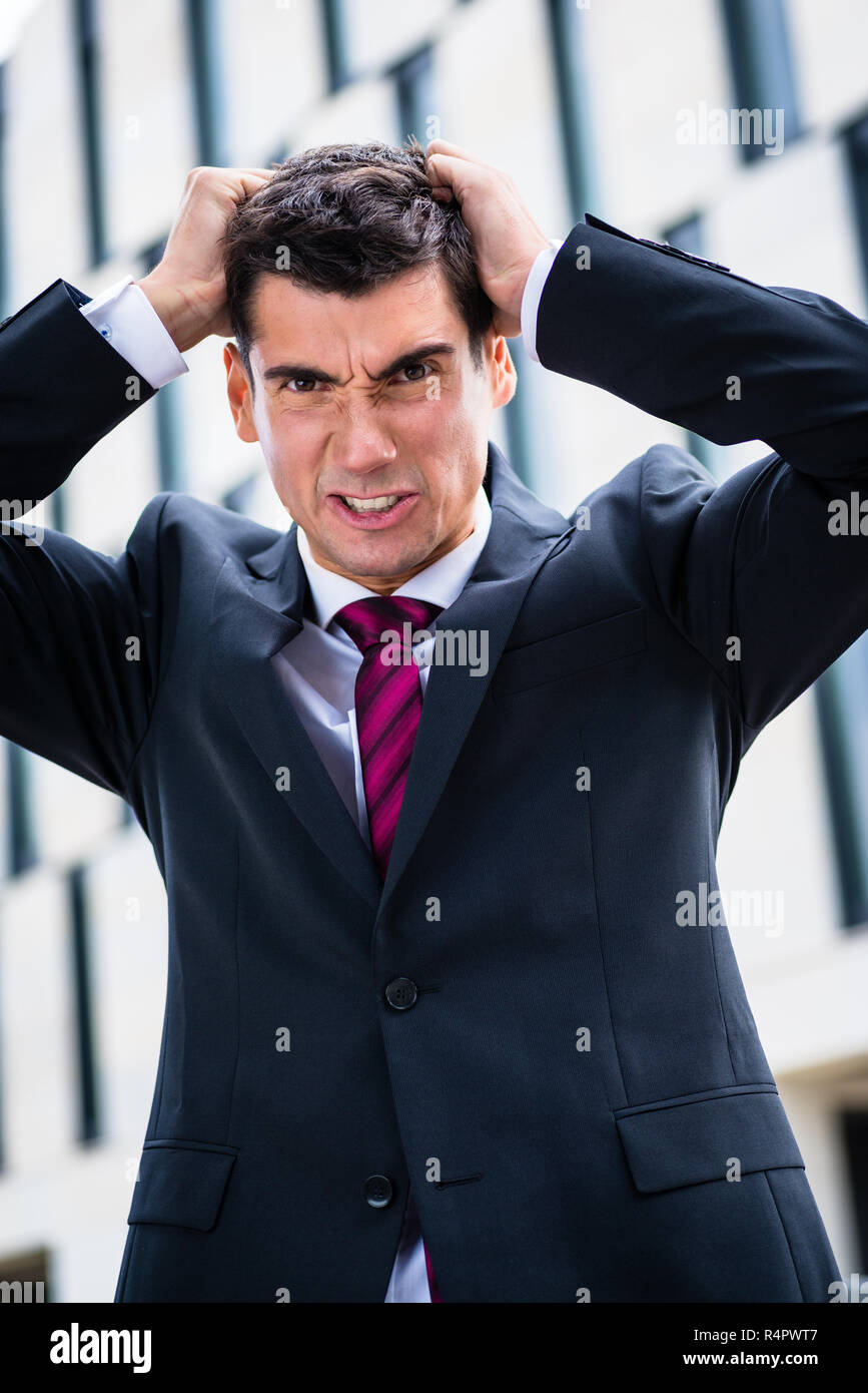 Angry business man tearing hair in despair Stock Photo - Alamy