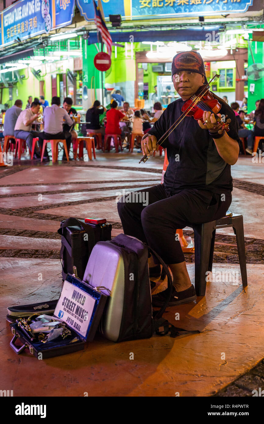 Street Musician at Nighttime Flea Market, Ipoh, Malaysia. Stock Photo