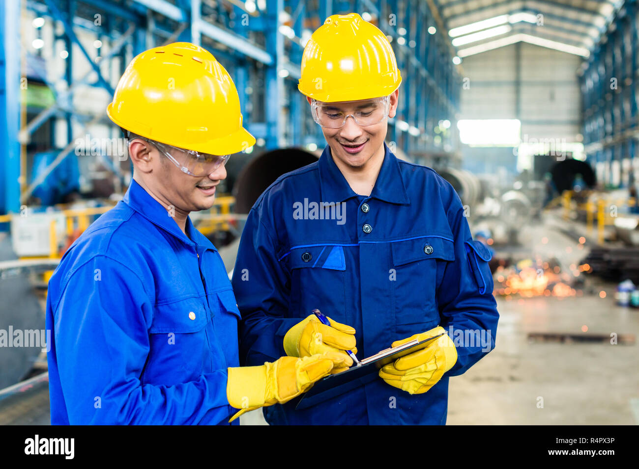 Two workers in production plant as team Stock Photo