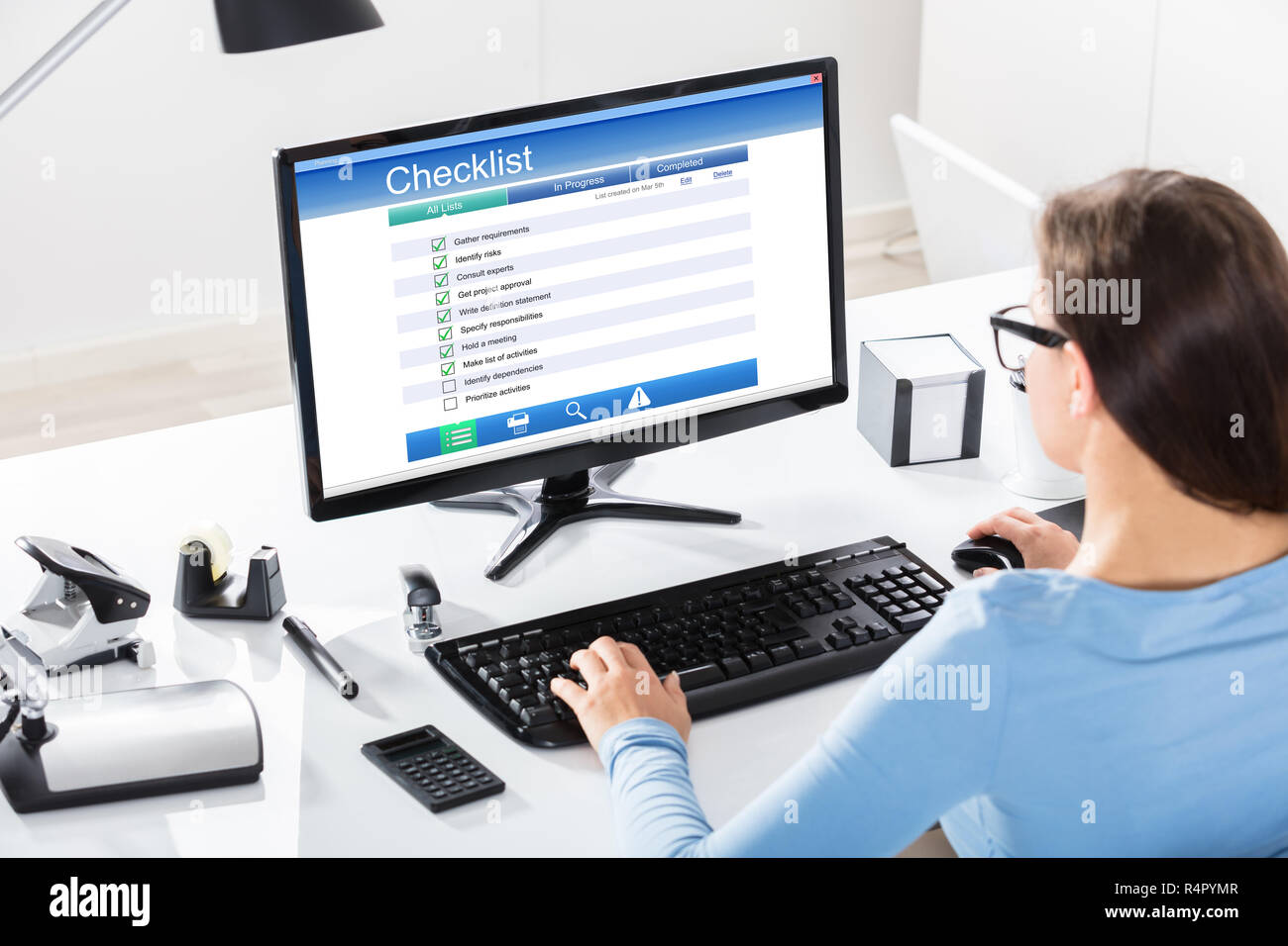 Businesswoman Filling Checklist Form On Computer Stock Photo - Alamy