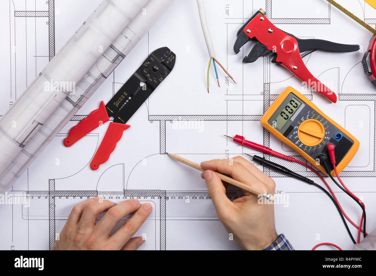 Architect Drawing Plan On Blueprint With Electrical Components Stock Photo