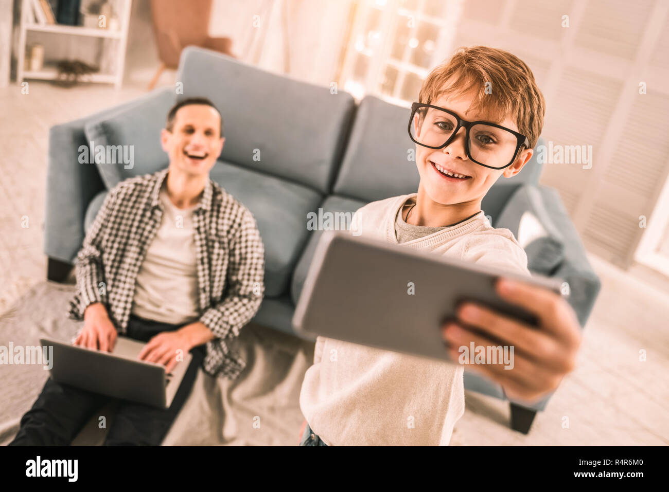 Happy father amused by his son's goofy behaviour. Stock Photo