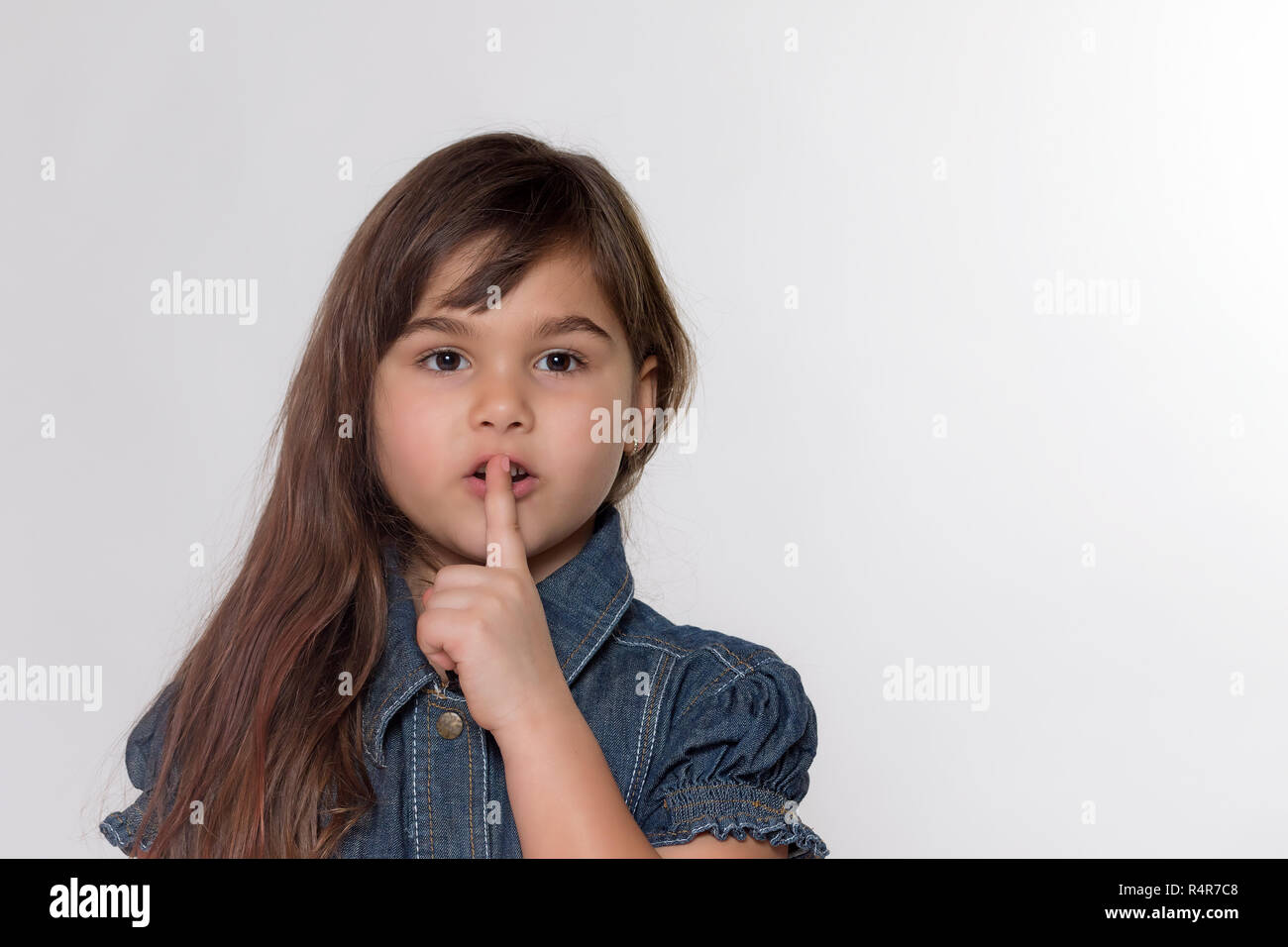 Portrait of little girl gesturing shush Stock Photo Alamy