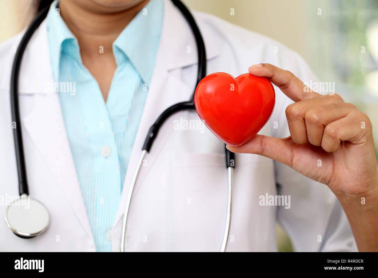 Female doctor holding a beautiful red heart shape Stock Photo - Alamy