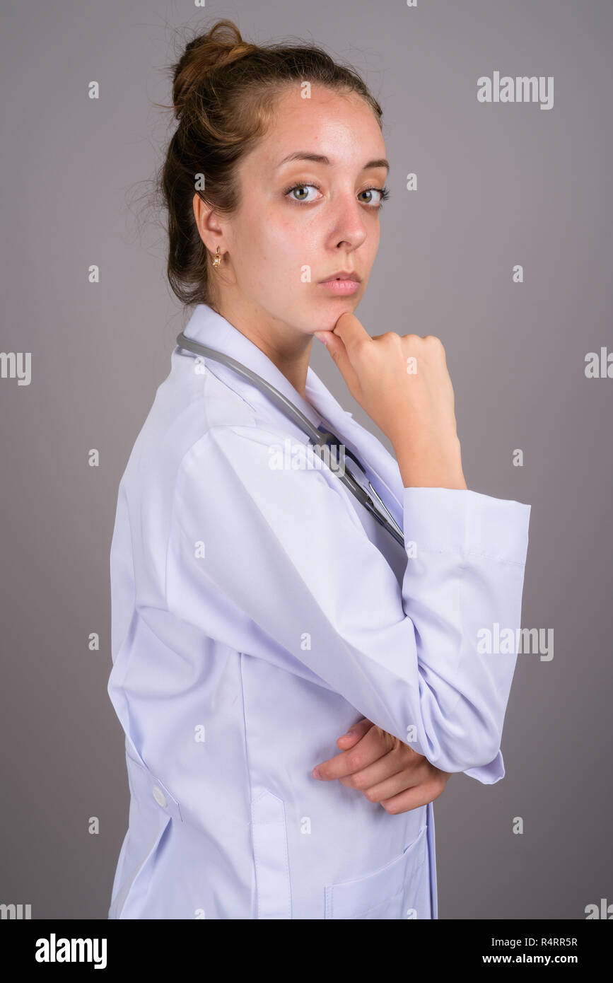 Young beautiful woman doctor against gray background Stock Photo
