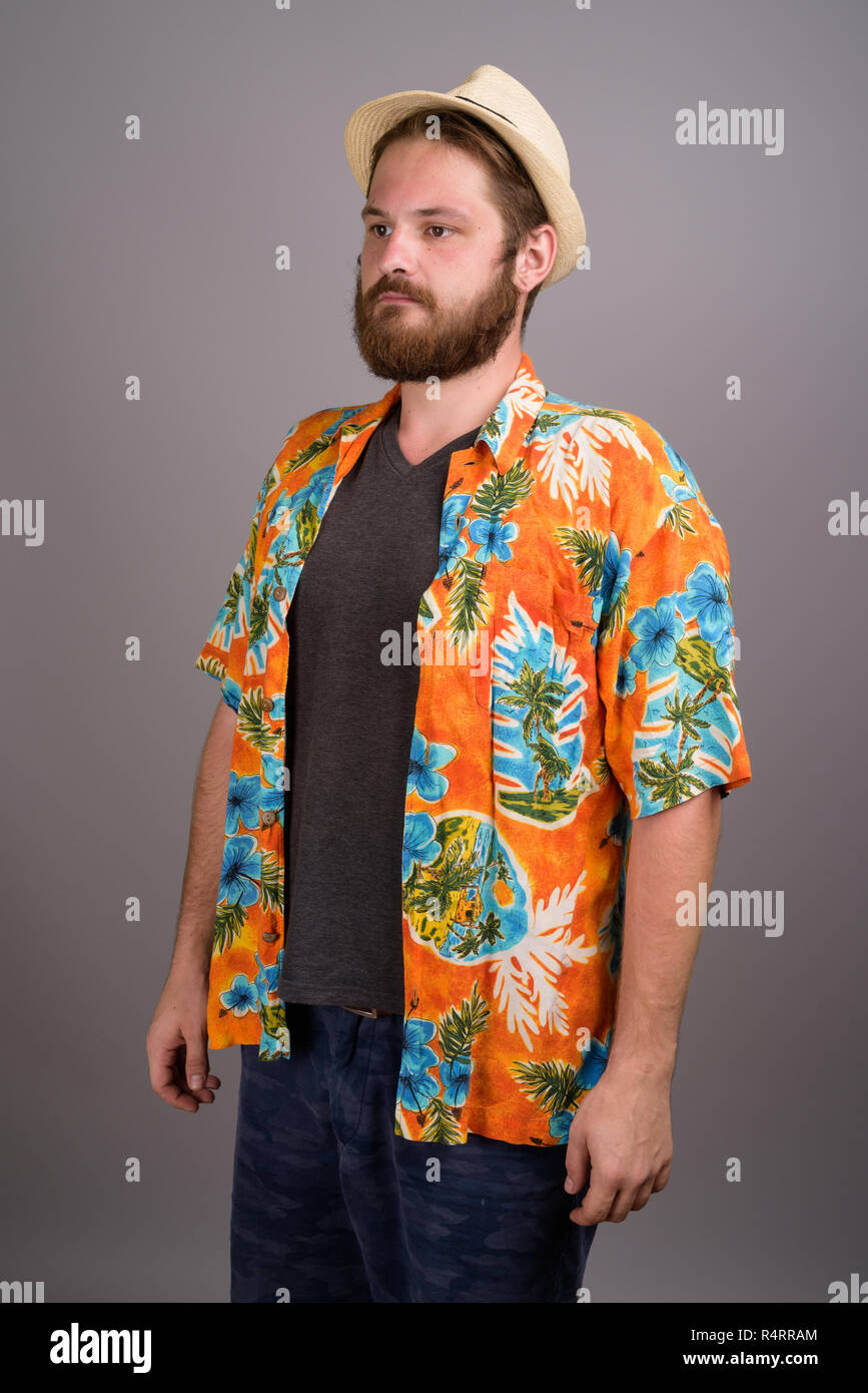 Young bearded tourist man ready for vacation against gray backgr Stock Photo