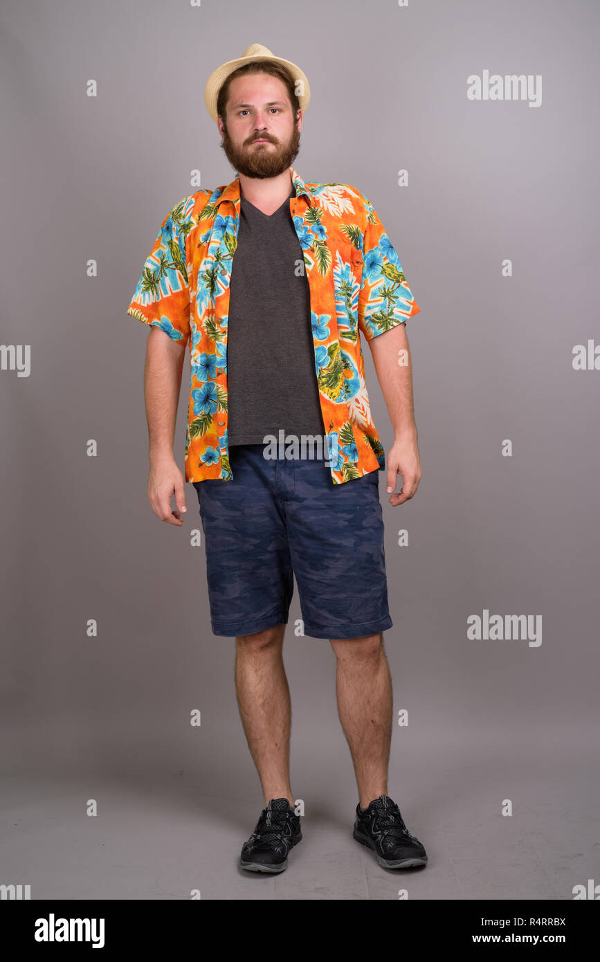Young bearded tourist man ready for vacation against gray backgr Stock Photo