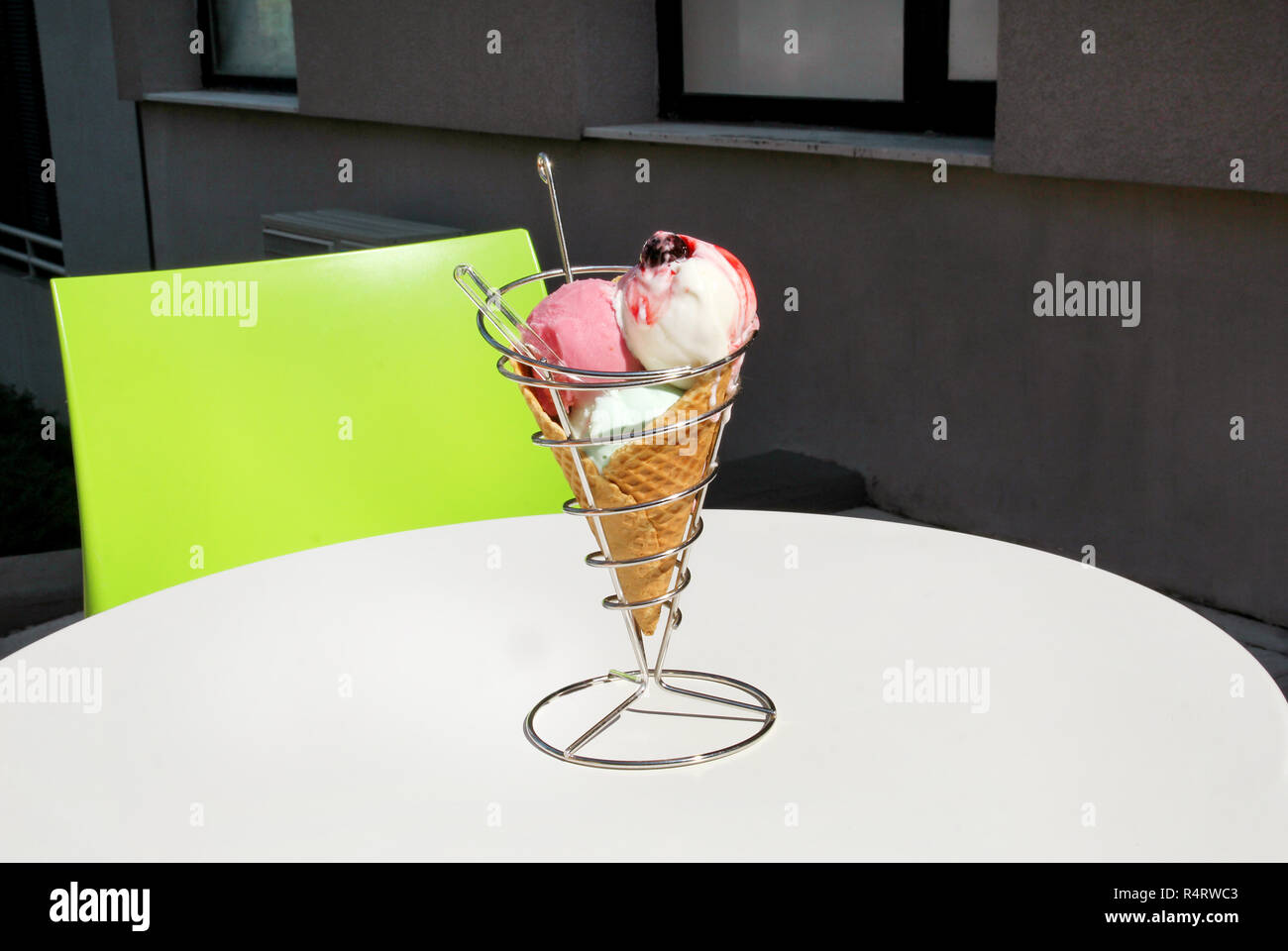 Ice cream holders on table. Strawberry, mint, vanilla with sour cherry