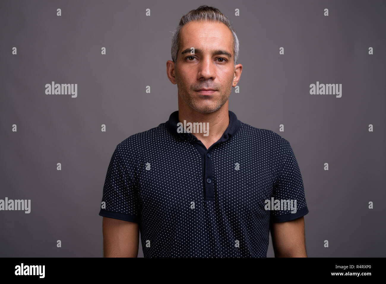Handsome Persian Man With Gray Hair Against Gray Background Stock