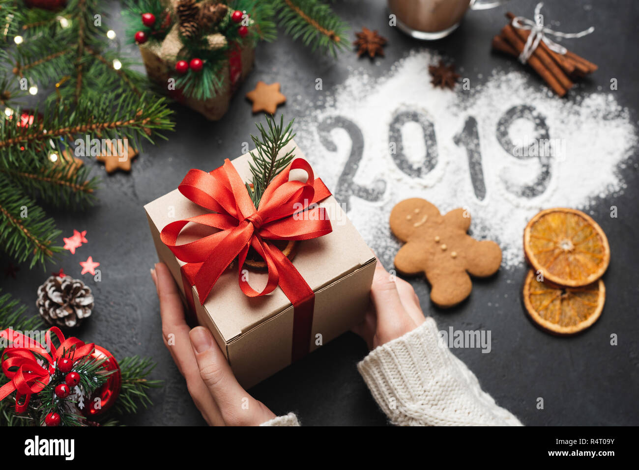 2019 Christmas New Year Greeting Card Gift Box. Hands Holding Gift Box. 2019 Number Written On Flour Stock Photo