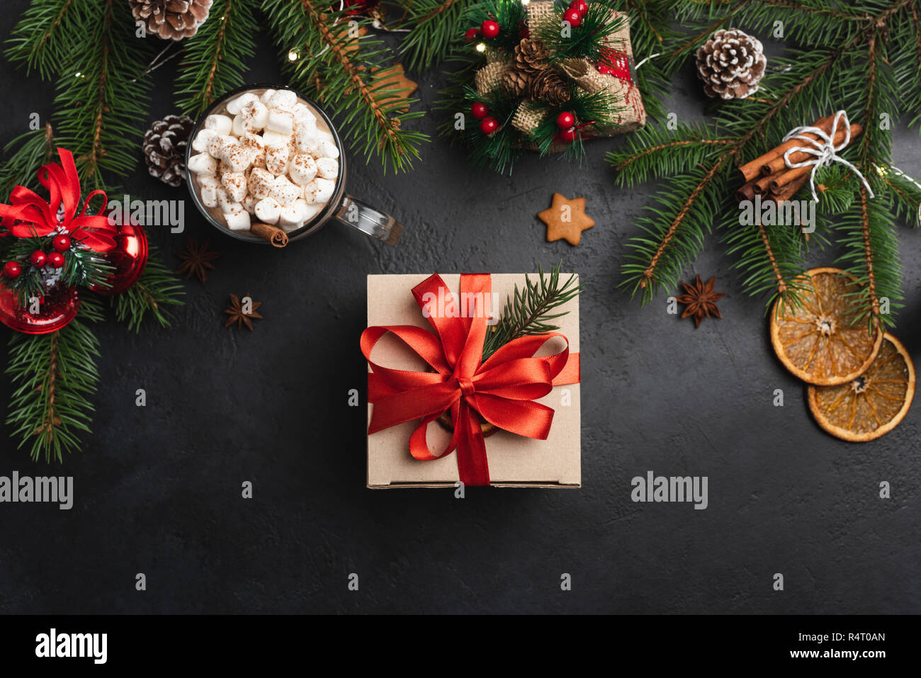 Gift box on black concrete background and Christmas decorations. Top view. Concept of New Year, Christmas, Winter holidays Stock Photo