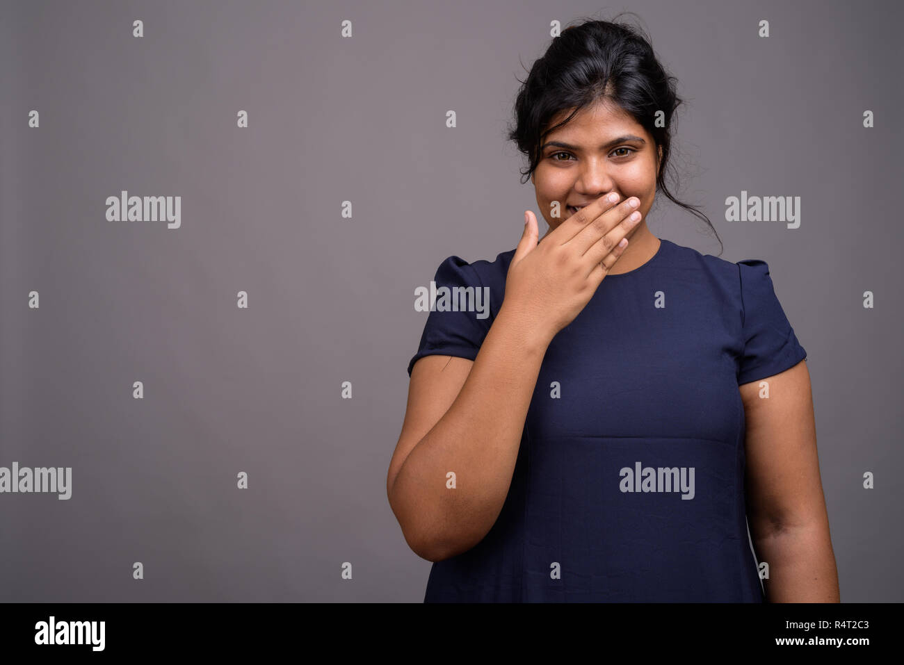 Young overweight beautiful Indian woman against gray background Stock Photo