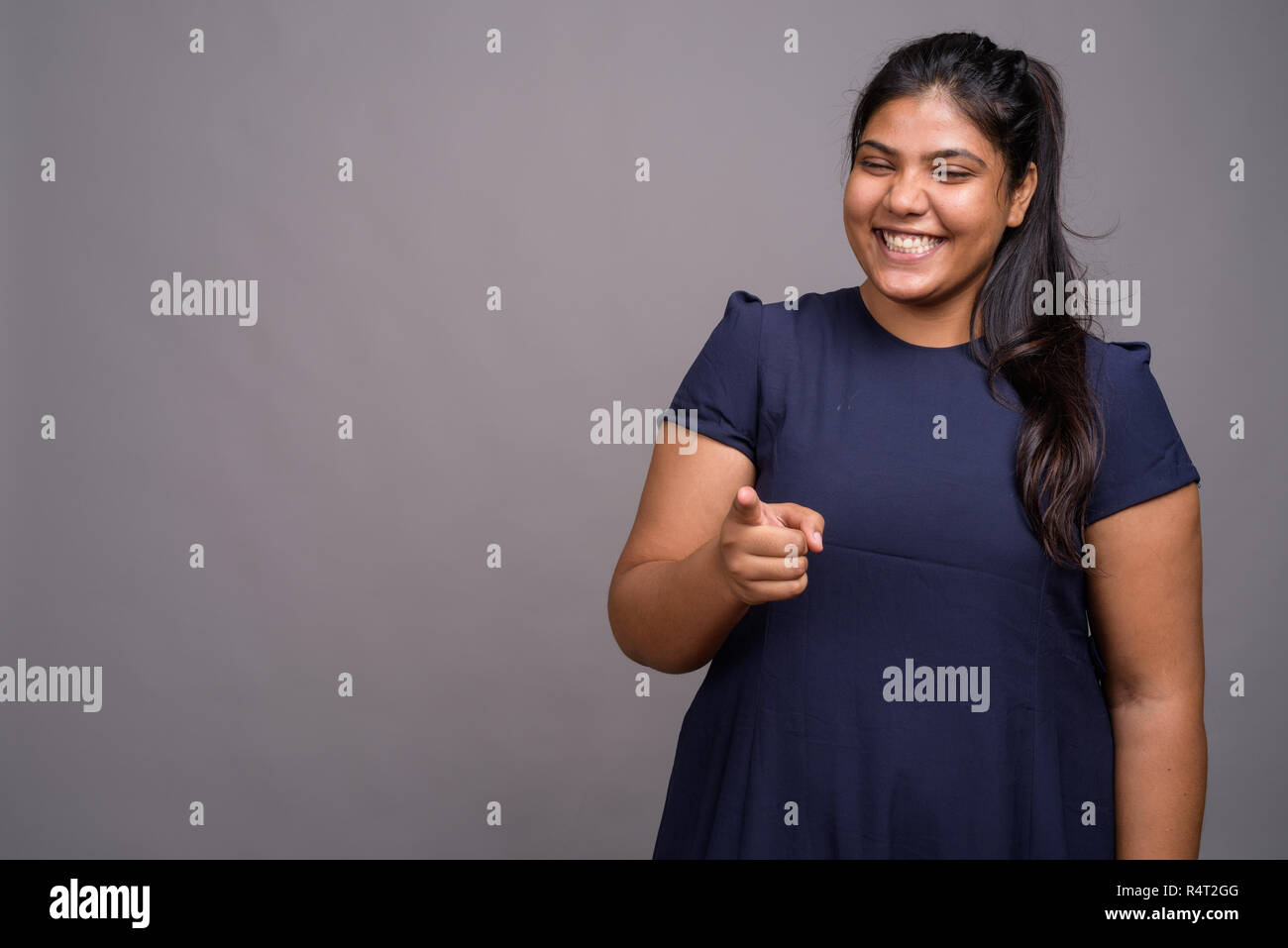Young overweight beautiful Indian woman against gray background Stock Photo