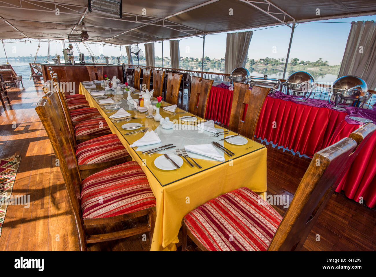 Large luxury traditional Egyptian dahabeya river boat sailing on the Nile with dining table