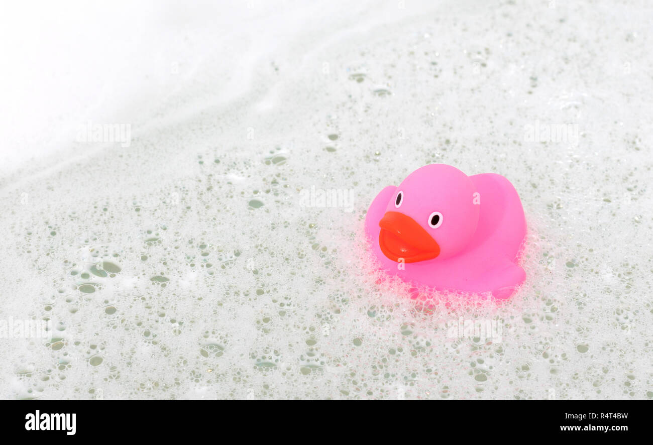 Pink duck in a bathtub, surrounded by soap Stock Photo Alamy
