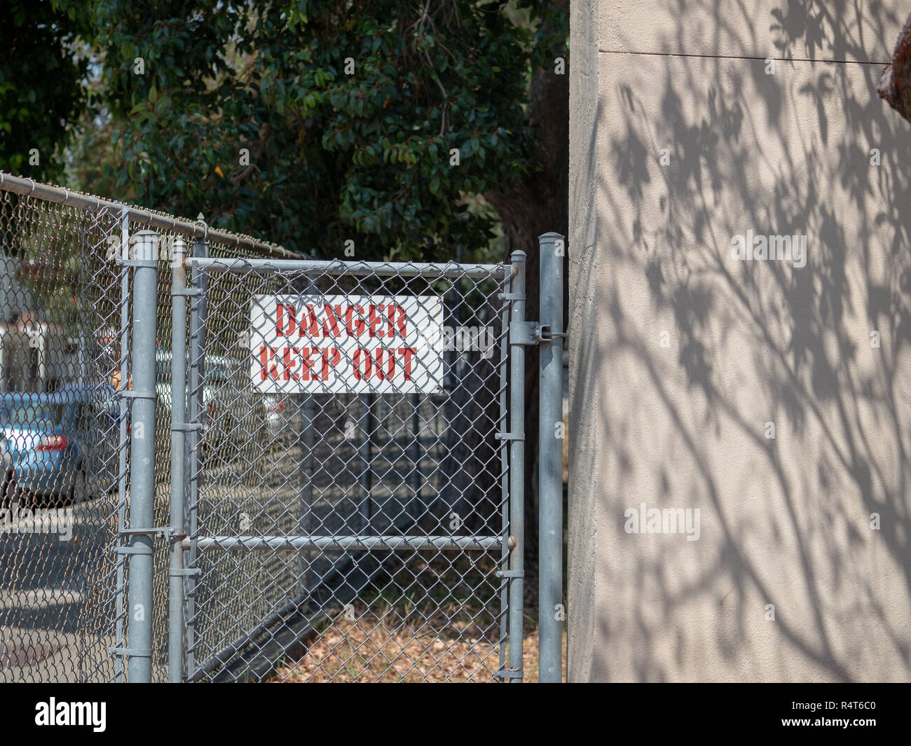 Danger keep out sign behind a residential chain link fence in residential area Stock Photo