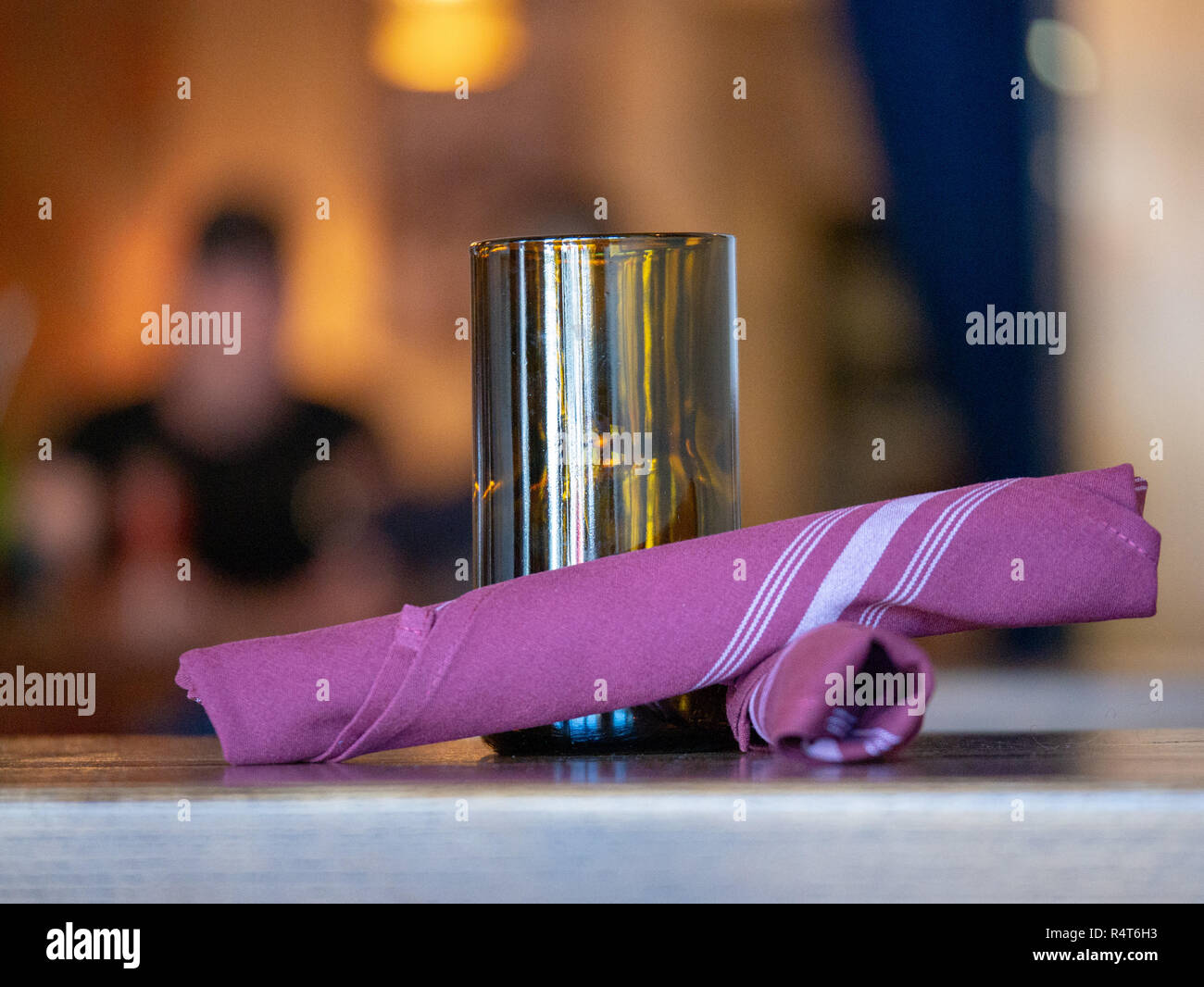 Various items on a restaurant table, napkins, candle, diners  Stock Photo