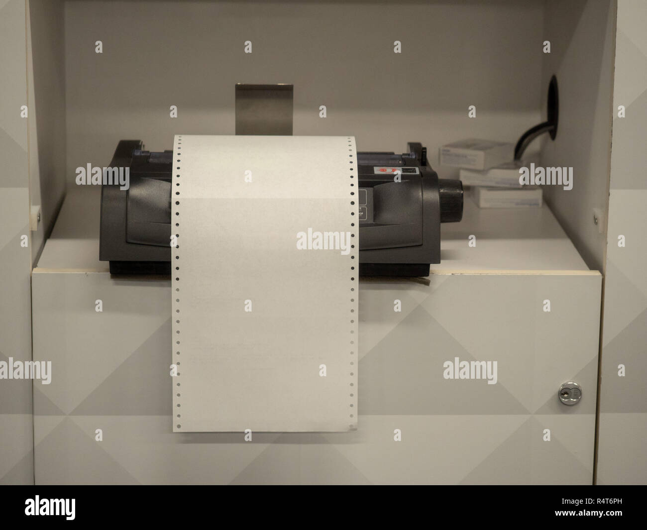 Printer sitting on shelf with overflowing blank white paper Stock Photo
