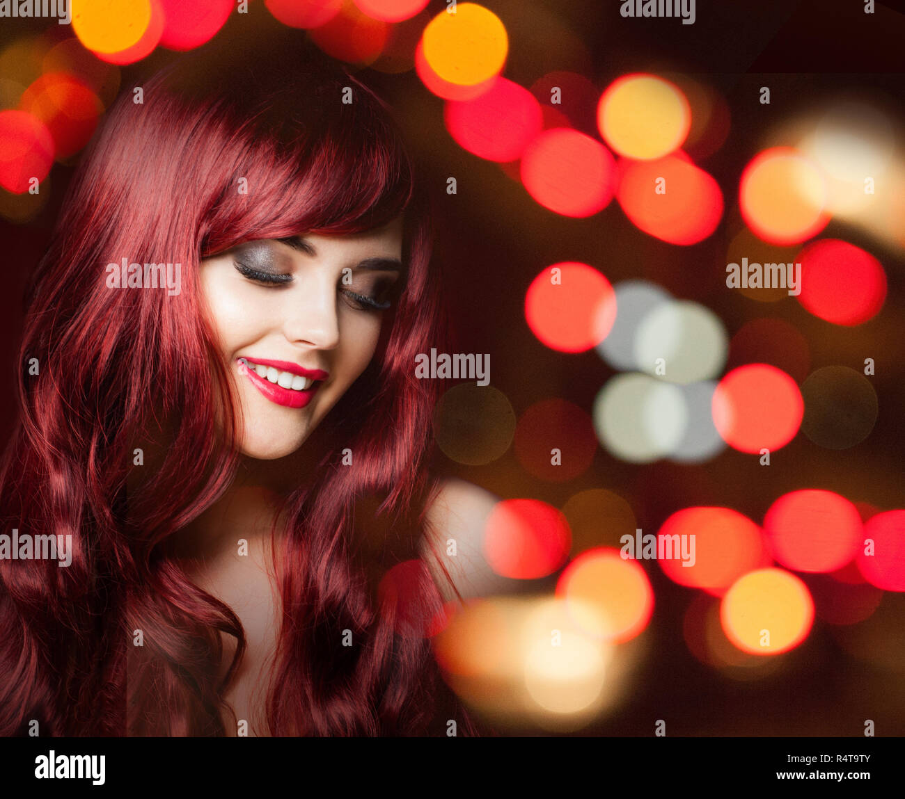 Cheerful redhead woman with long red curly hairstyle on bright color ...