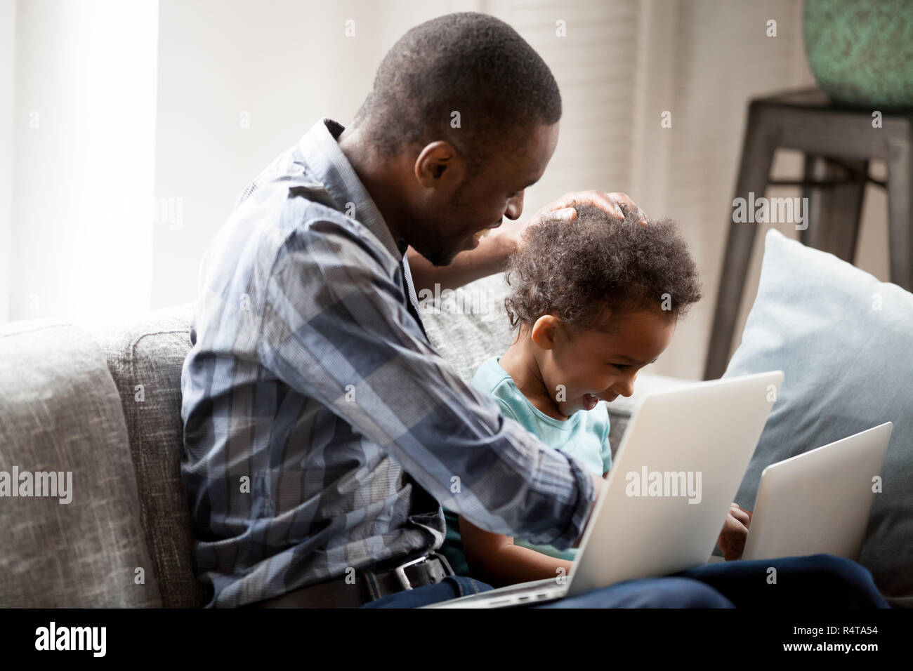 Happy African American family using laptop together at home Stock Photo ...