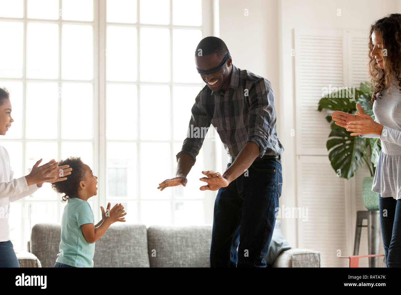 Happy African American family playing hide and seek at home Stock Photo