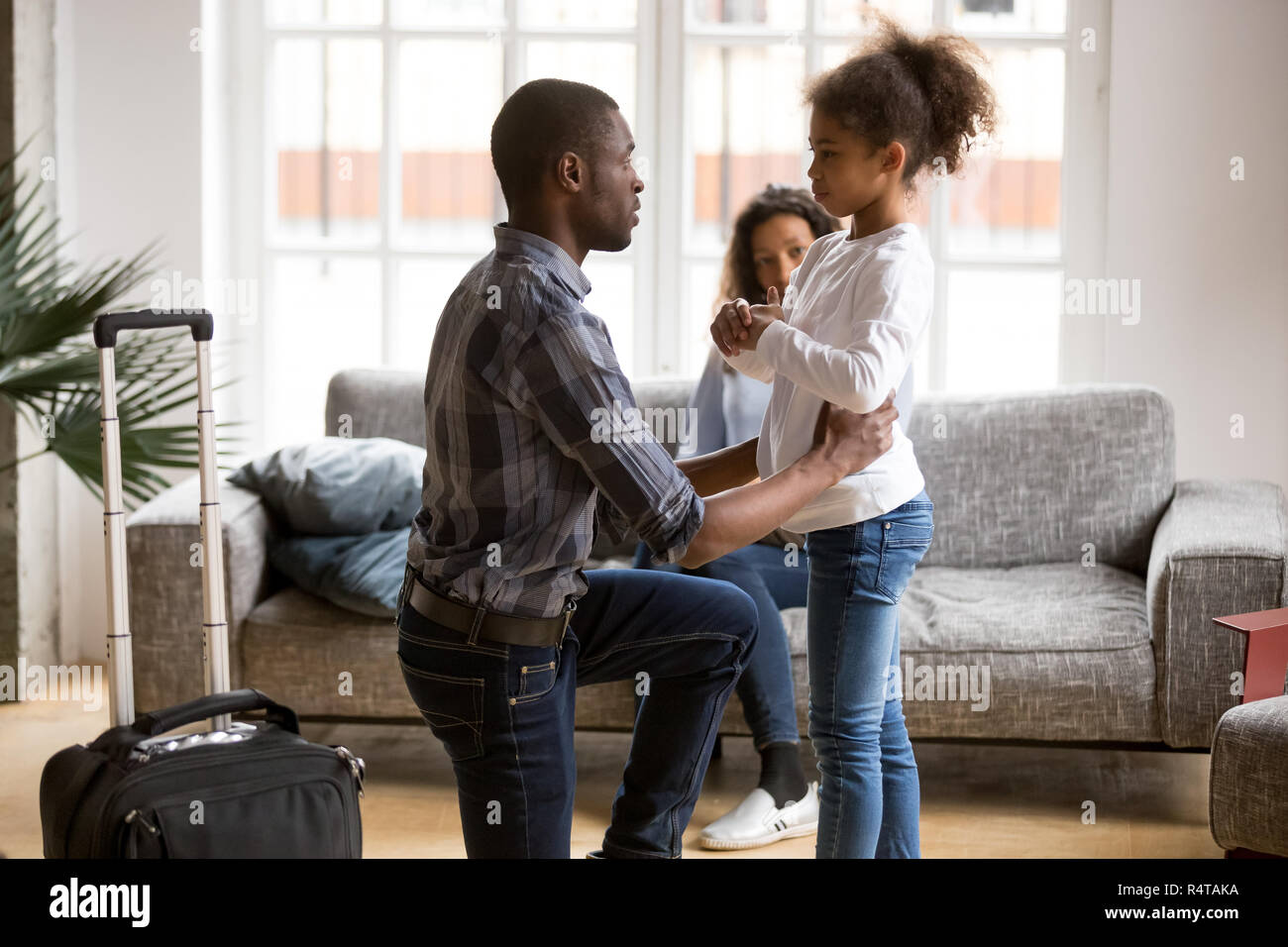 Unhappy African American father saying goodbye to daughter Stock Photo