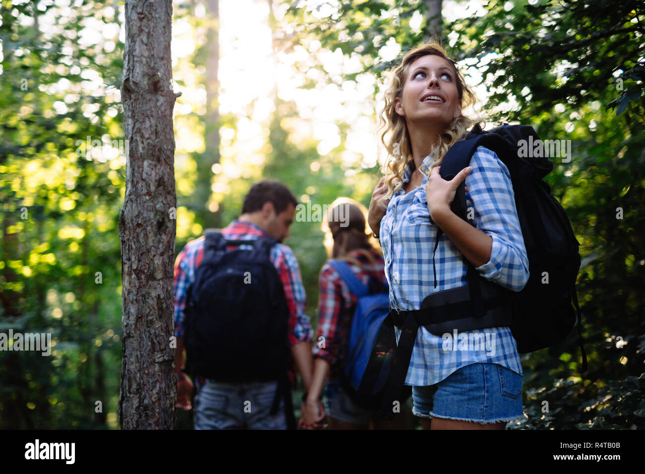 Group of young and happy people hiking in forest Stock Photo - Alamy
