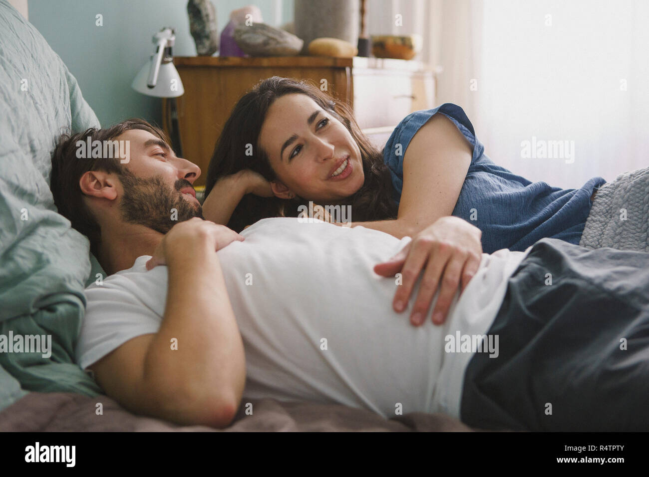 Couple relaxing and talking on bed Stock Photo