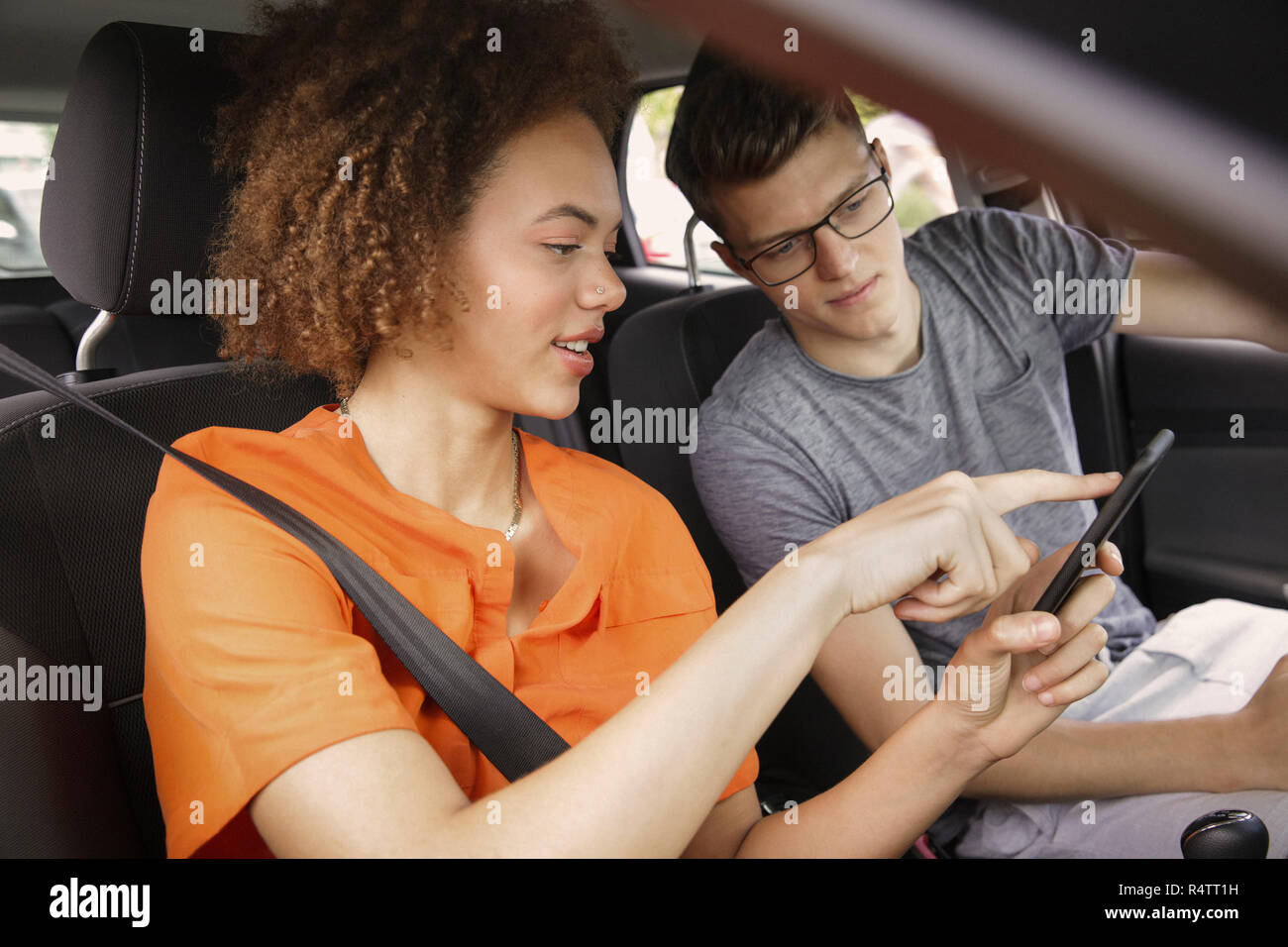 Young couple using smart phone GPS in car Stock Photo