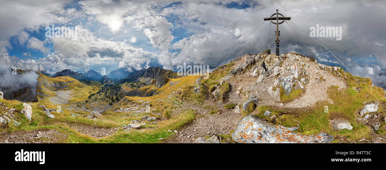 360° mountain panorama from Hochiss summit with summit cross and bizarre cloudy sky, Rofan mountains, Achensee, Maurach, Tyrol Stock Photo
