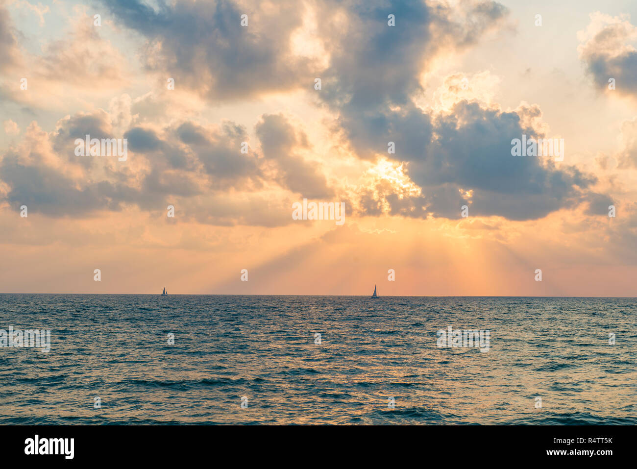 Sunset over the sea, sailboat on the horizon, Tel Aviv, Israel Stock Photo