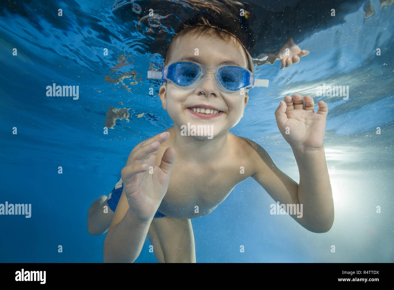 Young boy wearing swimming goggles dives in a pool Stock Photo Alamy