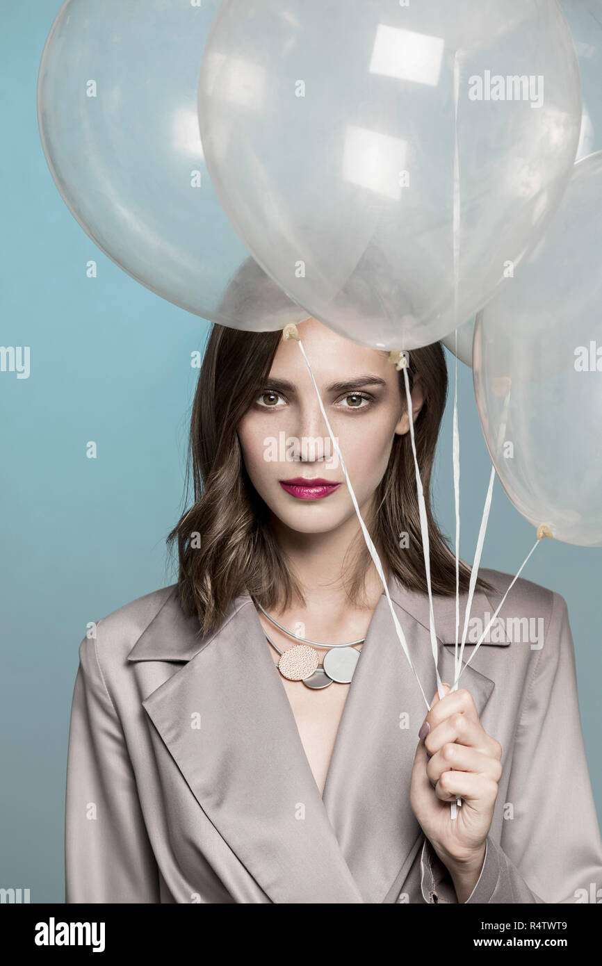 Portrait of female fashion model holding balloons Stock Photo
