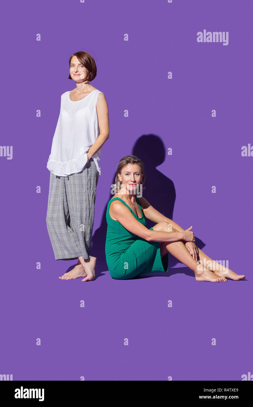 Portrait confident, barefoot women against purple background Stock Photo