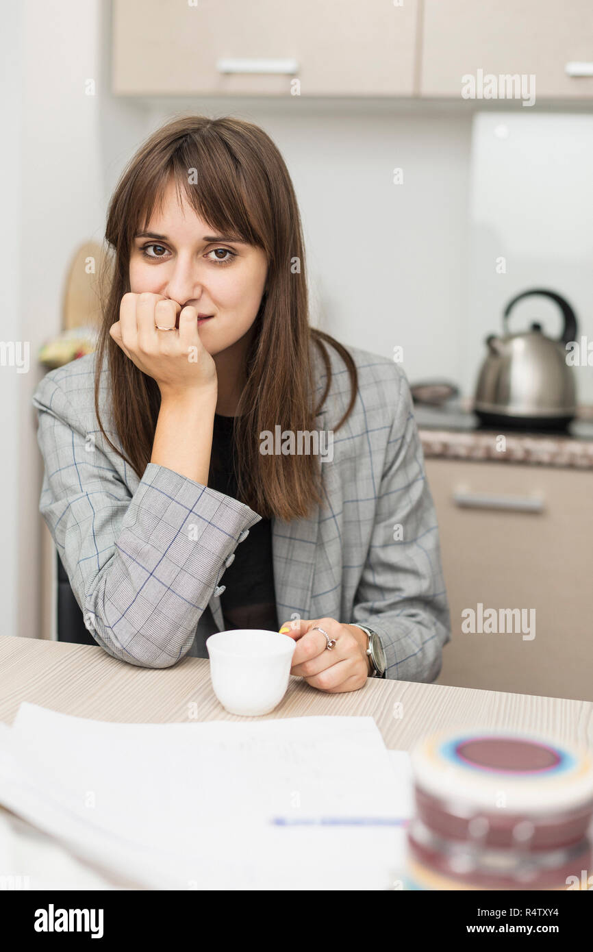 Portrait of woman sitting in kitchen Stock Photo
