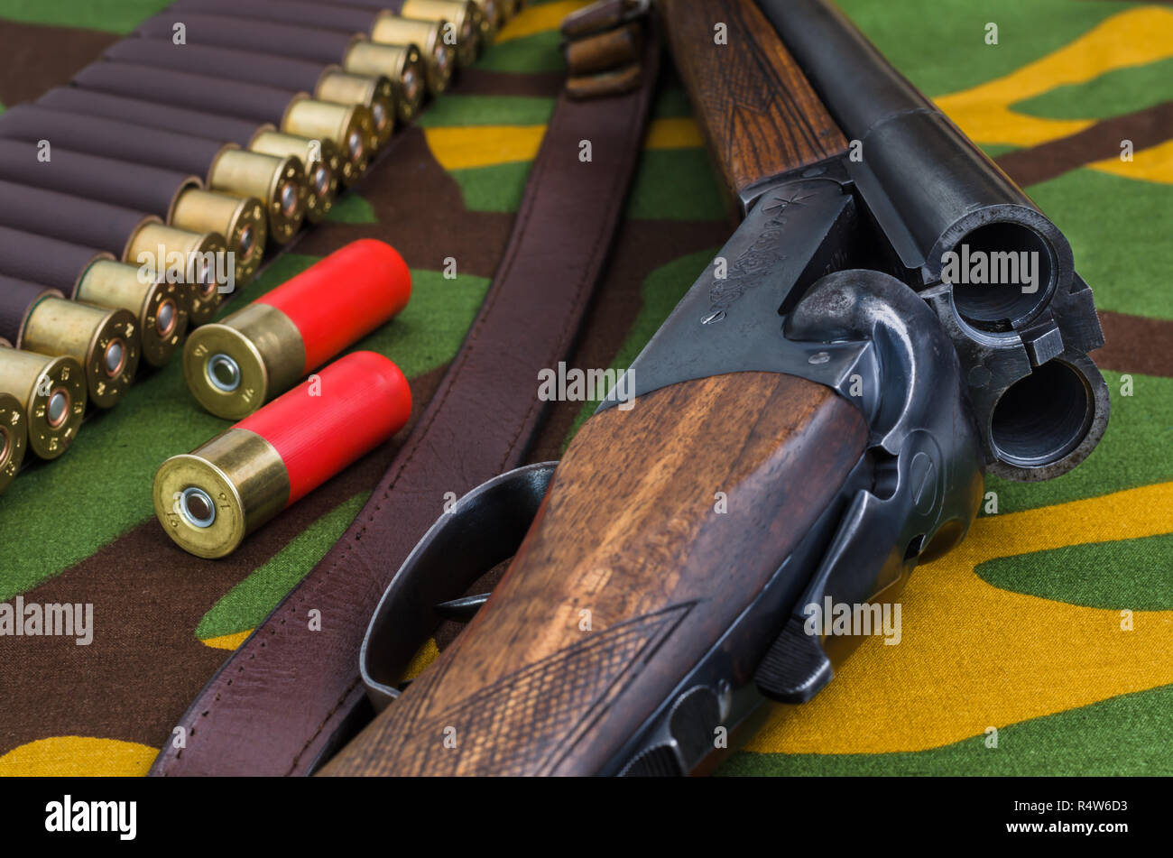 Hunting rifle and ammunition on a camouflage background. Stock Photo