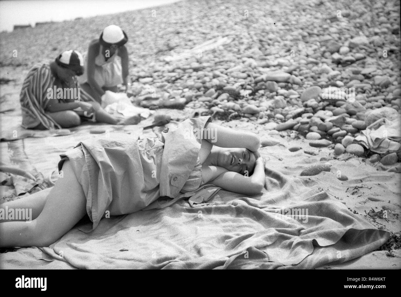 Young woman lying on pebble beach New Jersey USA 1940s Stock Photo