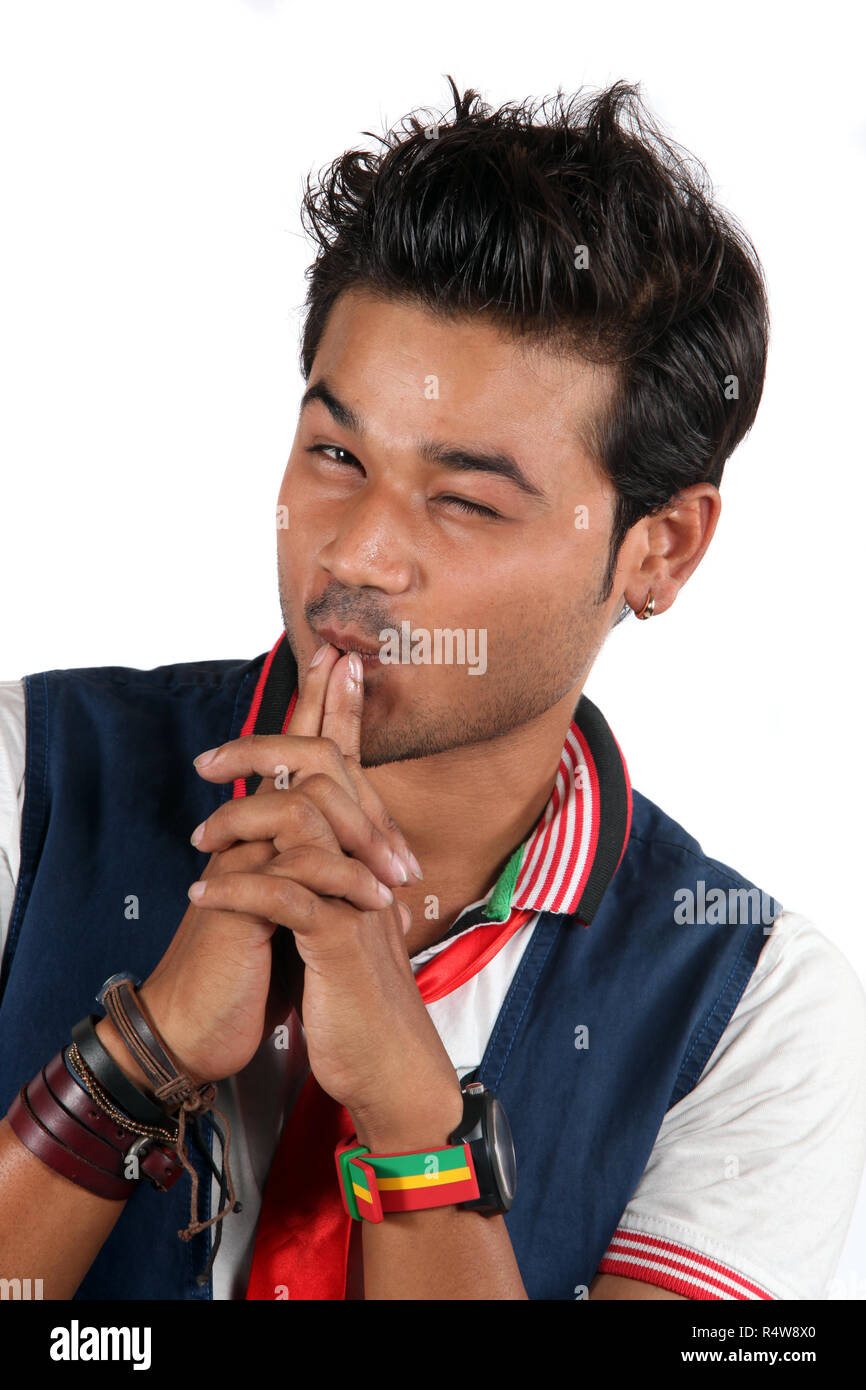 A young stylish Indian guy winking, on a white studio background Stock Photo