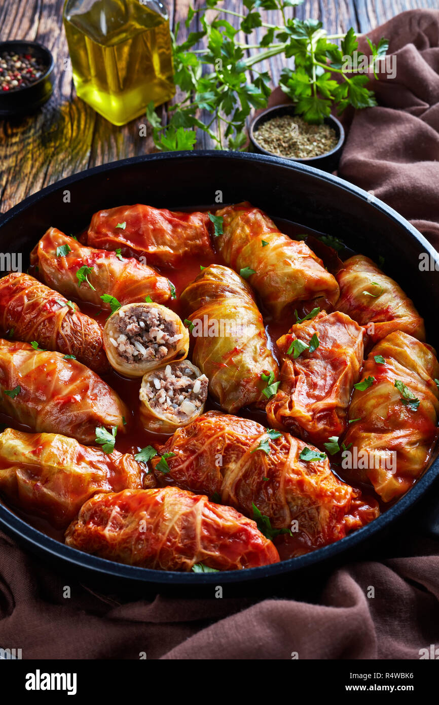 cabbage rolls stuffed with ground beef and rice and baked to perfection with a tangy tomato sauce in a dutch oven, vertical view from above, close-up Stock Photo