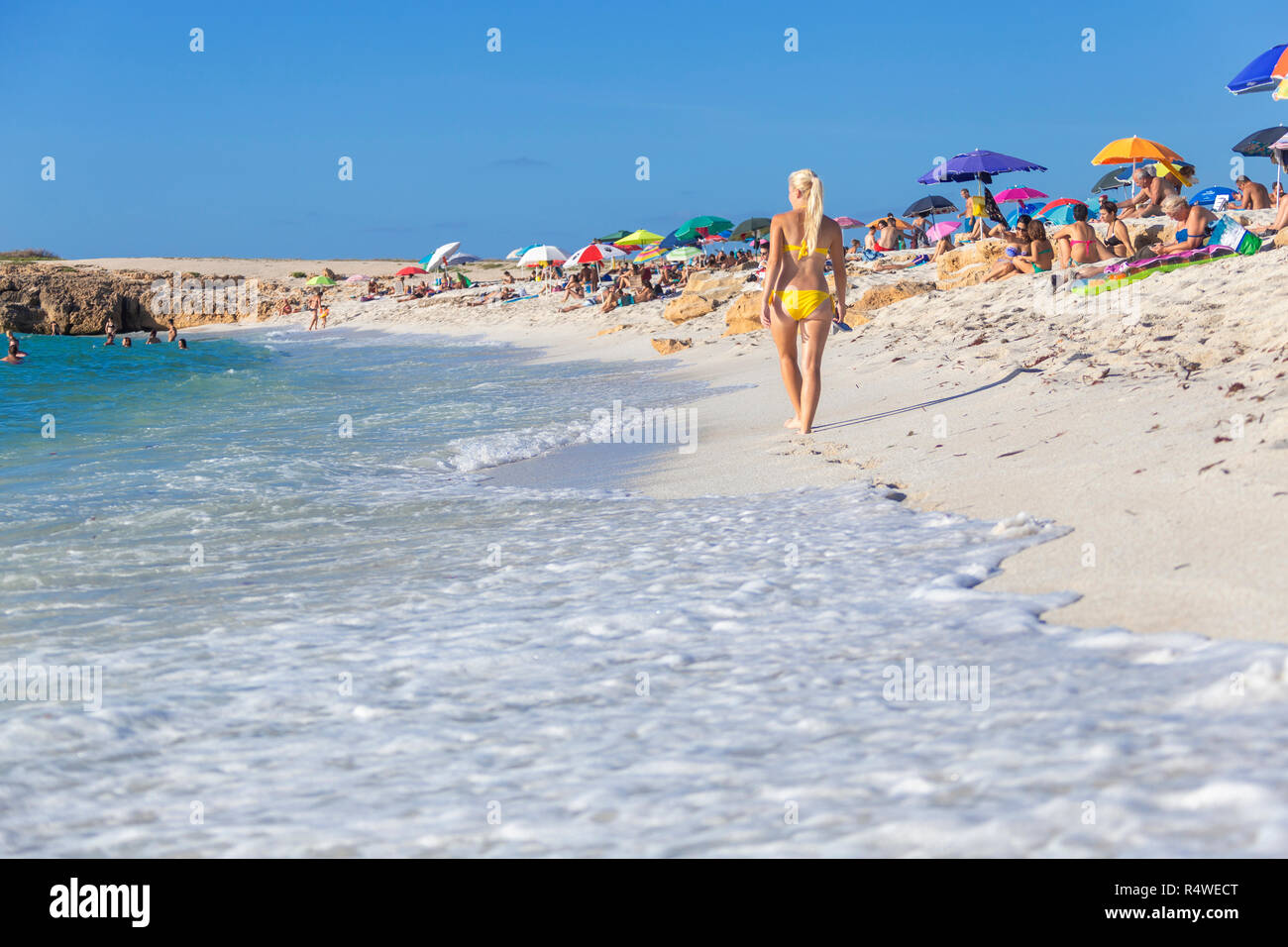 Young girl wit yellow swimsuit walks on the beach of Is Arutas, Cabras, Oristano province, Sardinia, Italy, Europe. Stock Photo