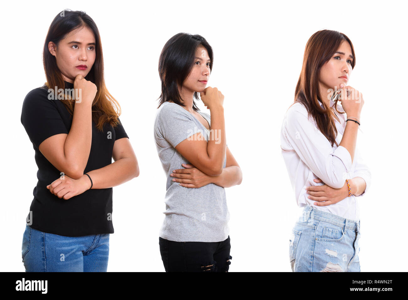 Studio shot of three young Asian woman friends thinking while lo Stock Photo