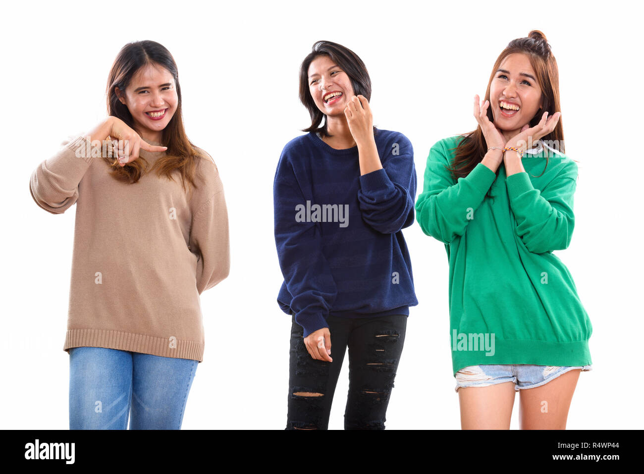 Three happy young Asian woman friends smiling and making funny f Stock Photo