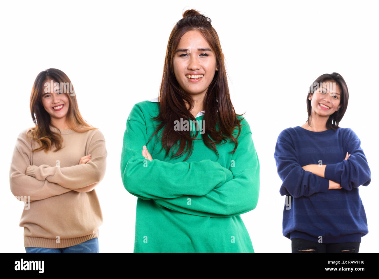 Studio shot of three happy young Asian woman friends smiling wit Stock Photo