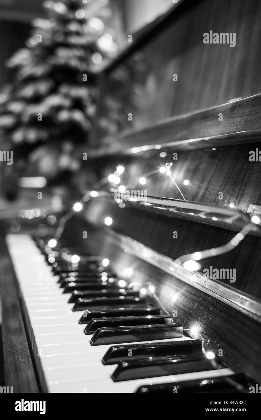 Piano keyboard illuminated with christmas lights. Romantic music background  Stock Photo - Alamy