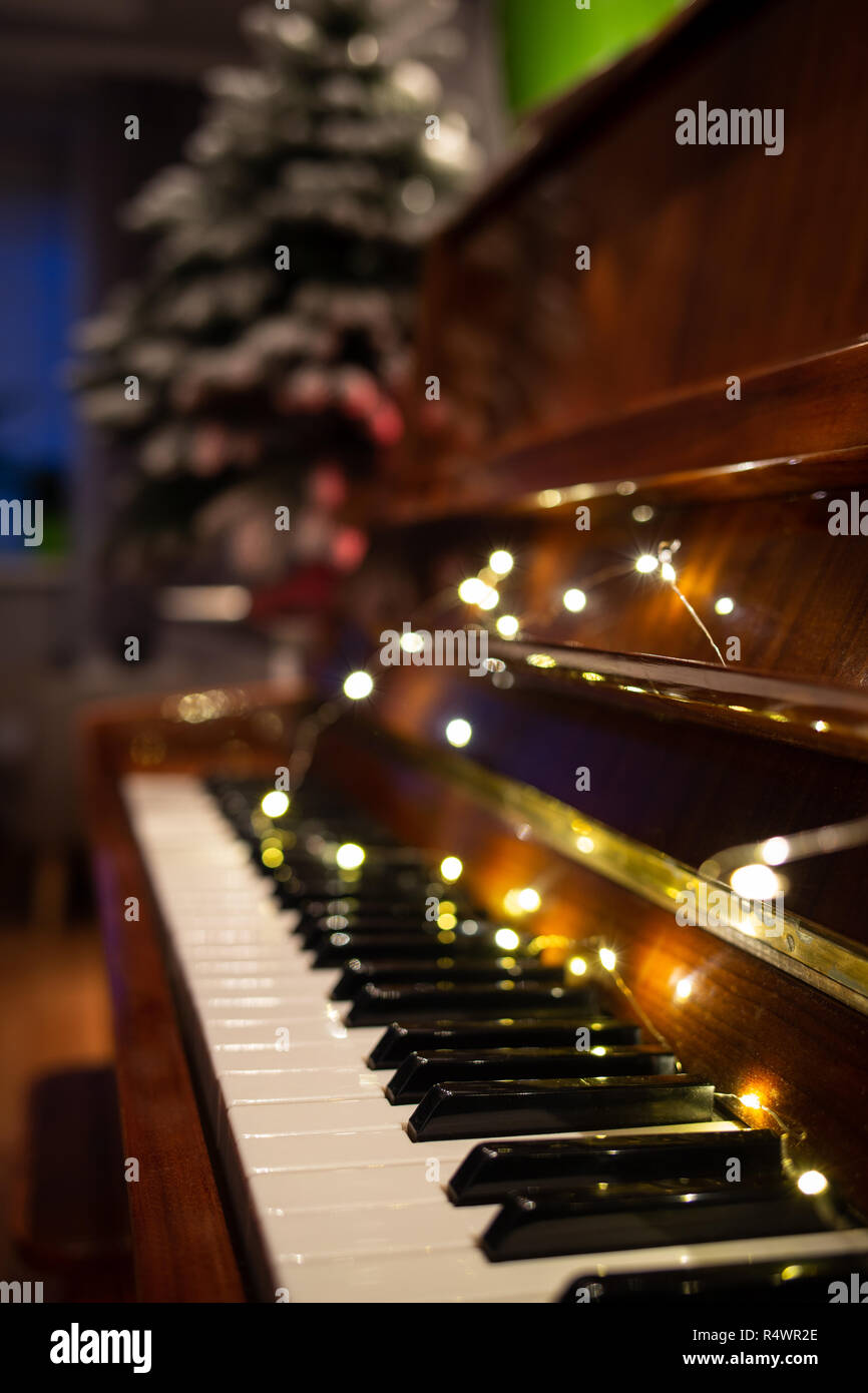 Piano keyboard illuminated with christmas lights. Romantic music