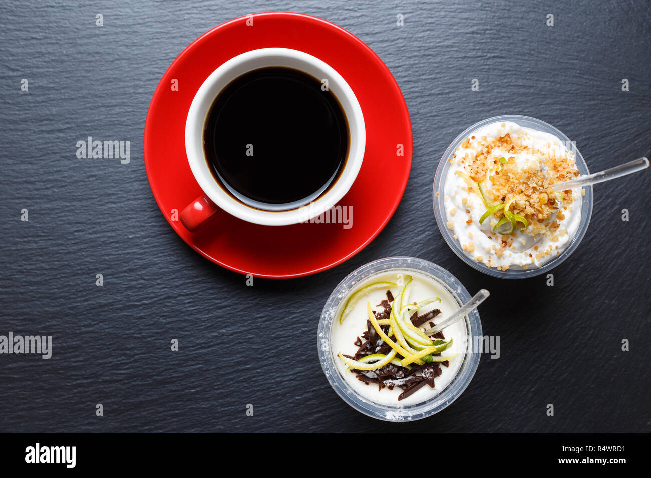 Red cup of coffee with take away desserts on black slate background Stock Photo