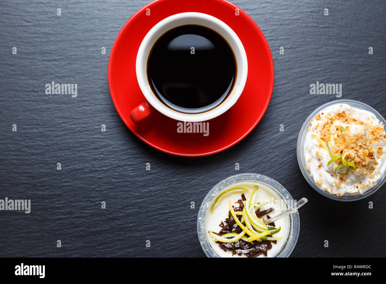 Red cup of coffee with take away desserts on black slate background Stock Photo