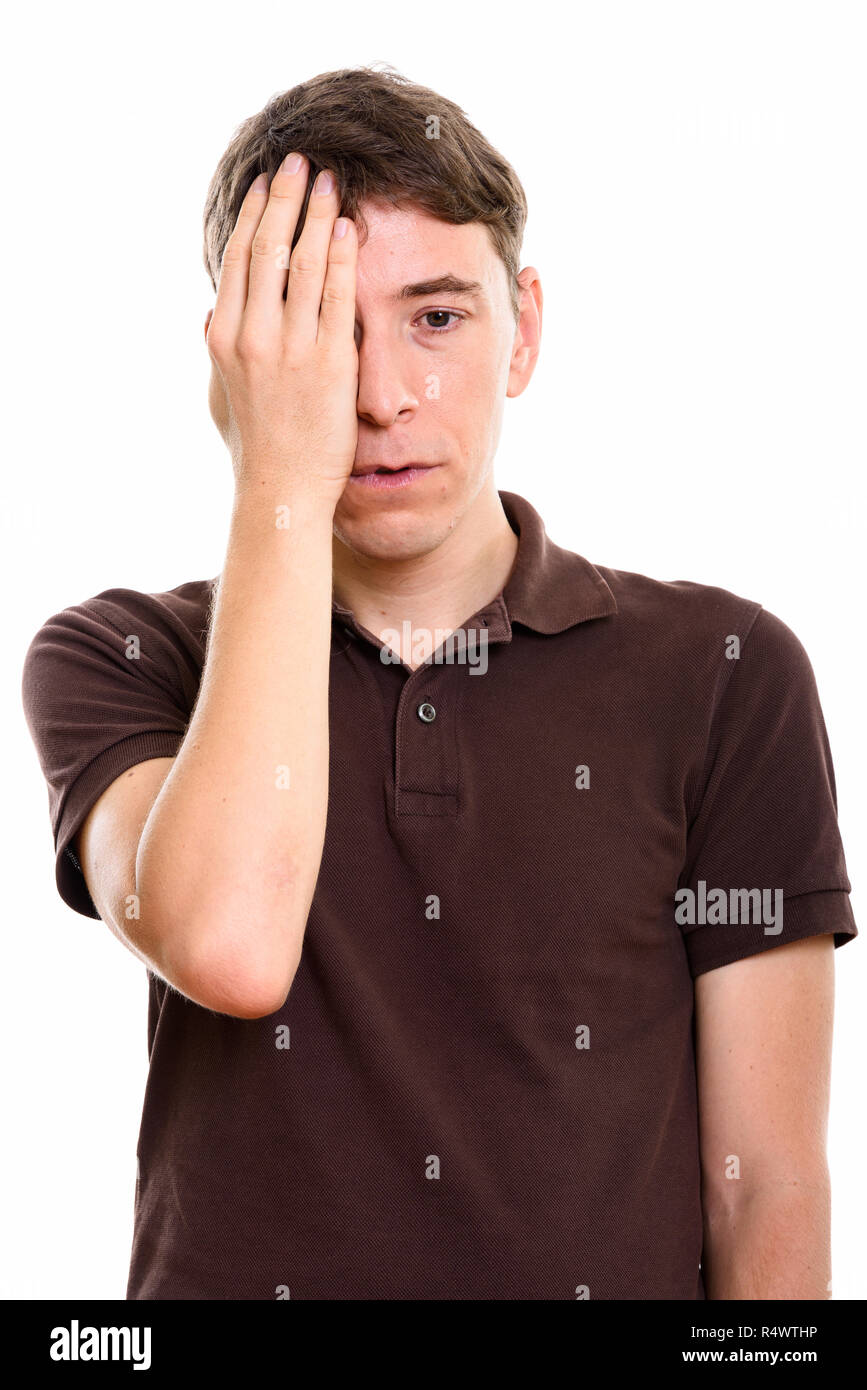Studio shot of stressed man covering face with hand Stock Photo