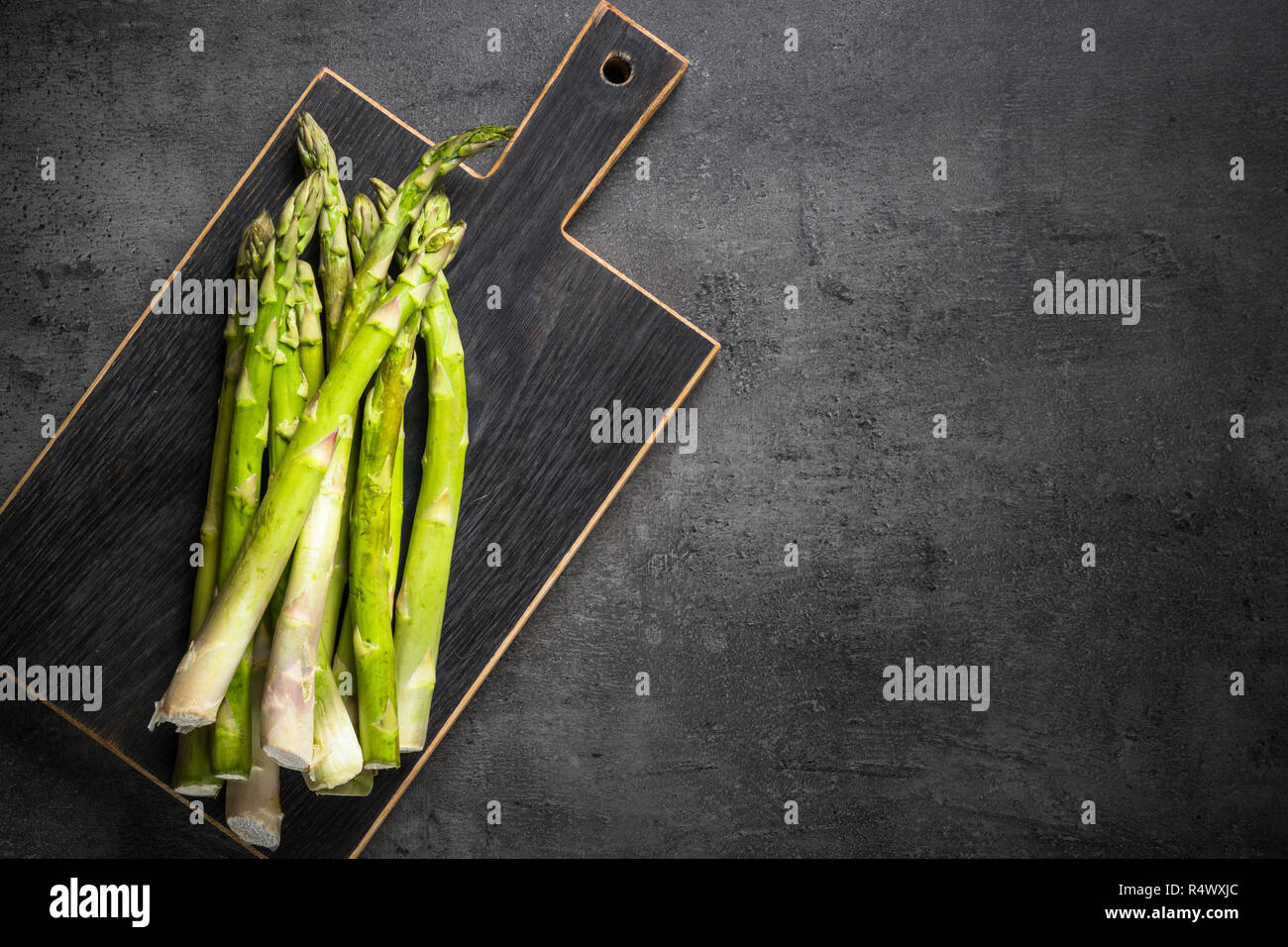 Fresh green asparagus on black slate background. Stock Photo