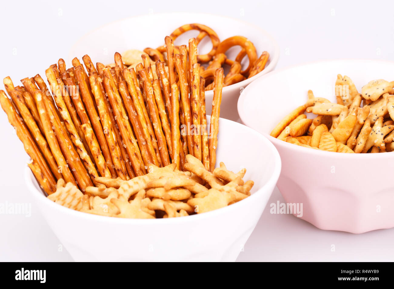 Different salted crackers in bowls on white background. Stock Photo
